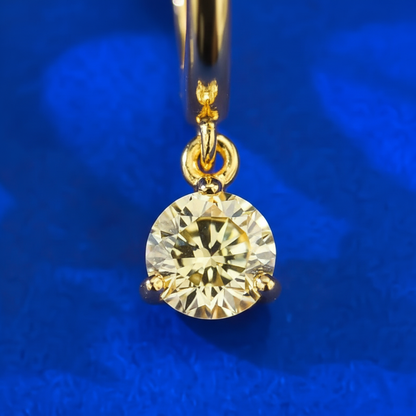 Close-up detail of gold hoop and yellow diamond drop pendant