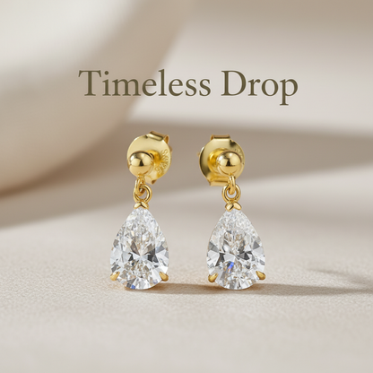 Pear-shaped diamond earrings with "Timeless Drop" text overlay