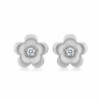 Silver brushed flower stud earrings on white background