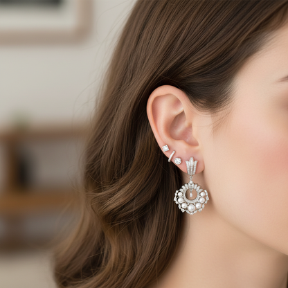 Small delicate pearl and diamond chandelier earrings styled with other earrings showing ear stacking