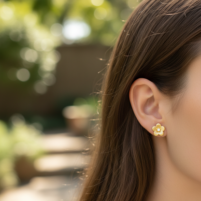 Woman wearing small delicate gold brushed flower stud earrings - lifestyle shot 2
