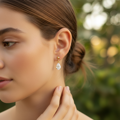 Woman wearing small delicate pear-shaped diamond drop earrings - lifestyle shot 2